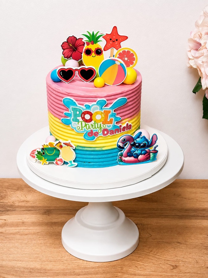 Tarta de fiesta de piscina a rayas de colores con flotadores, gafas de sol y frutas