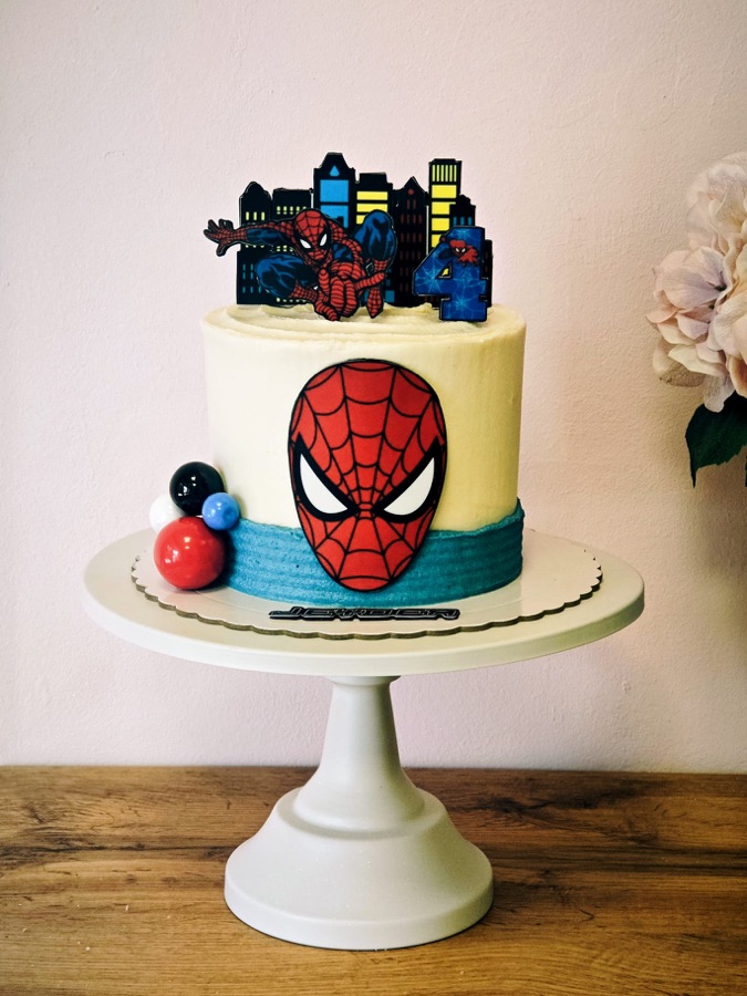 Tarta de Spiderman con la máscara modelada y la silueta de la ciudad recortada